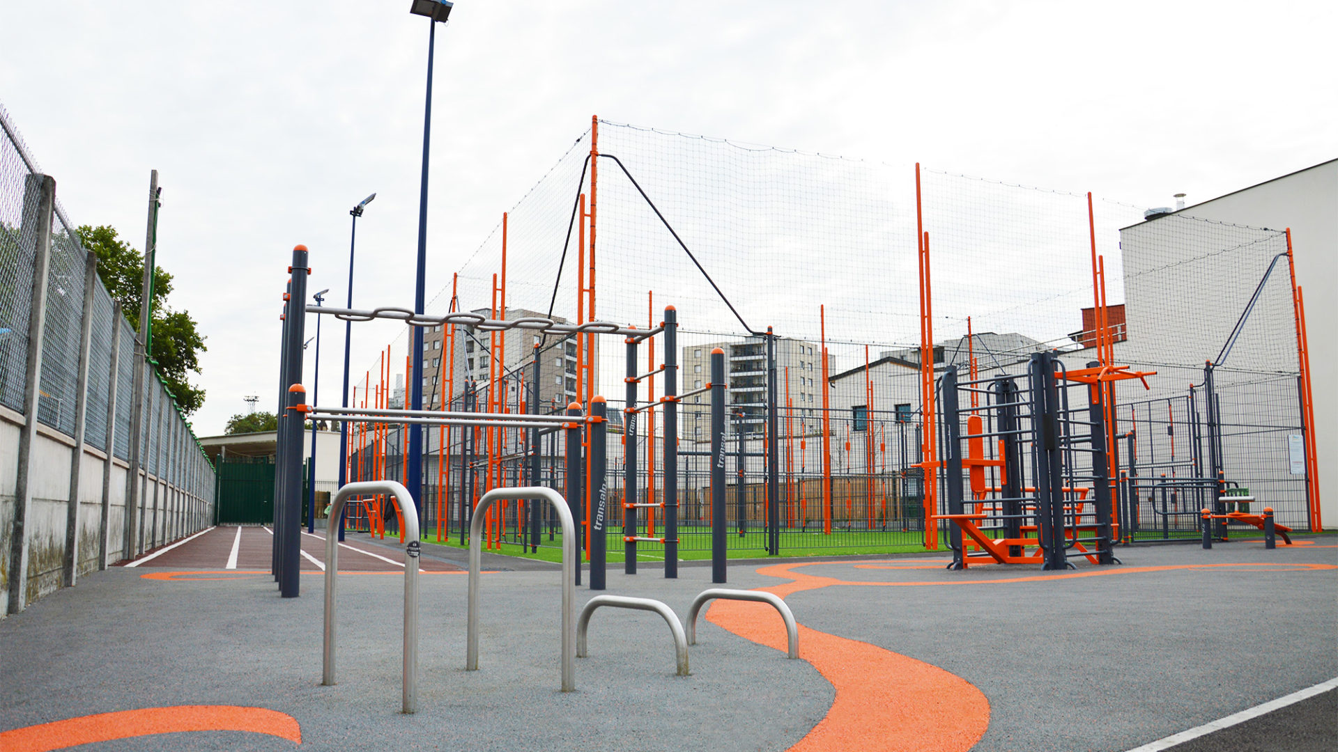 Terrain multisports en deux terrains sportifs, agrès de street-workout et piste d'athlétisme sur sol souple