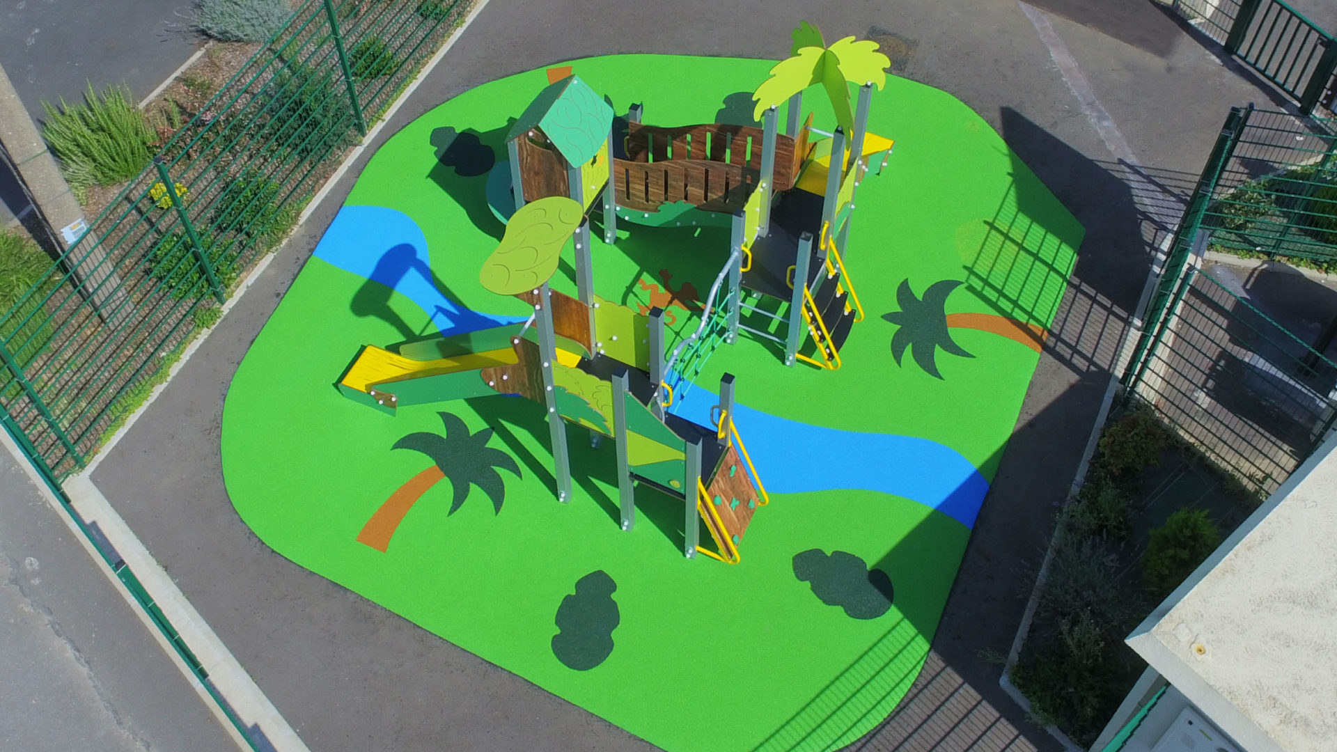 Aire de jeux thématique Jungle Luxuriante à Châtres, avec palmiers, rivière et petit singe en motifs de sol souple